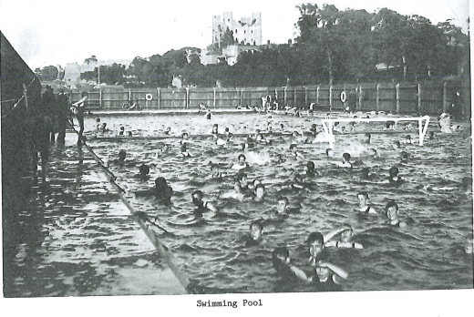 An old black and white photo of students in a pool